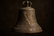 A weathered church bell with the image of Baja California eched on the face of the bell 